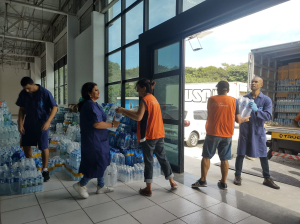 Voluntários carregando os caminhões de doações. 