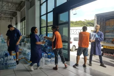 Voluntários carregando os caminhões de doações. 